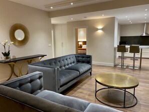 Suite – deluxe, 2 soverom | Oppholdsområde | En 55-tommers smart-TV med Parabol-TV samt TV og oppvarmet gulv