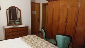 A bedroom with a bed, dresser, mirror, and wardrobe. - Albergo Ristorante La Campagnola (Urbana)