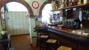 A bar area with a counter, stools, and a clock on the wall. - Albergo Ristorante La Campagnola (Urbana)
