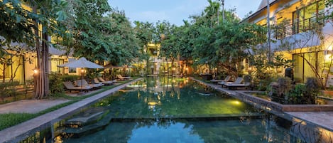 Una piscina al aire libre, camas de piscina gratis, sombrillas
