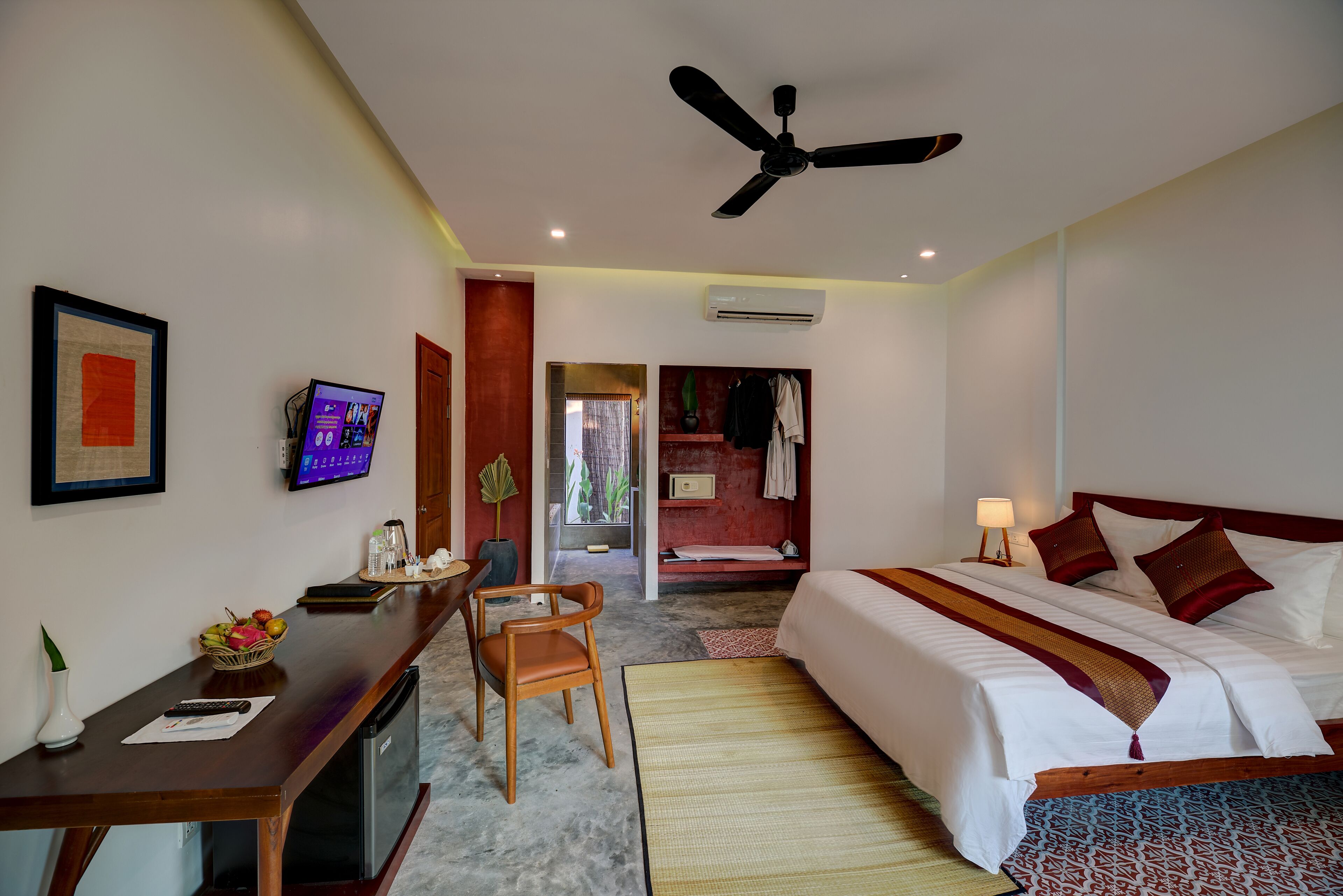 A hotel room with a bed, desk, chair, and a television.