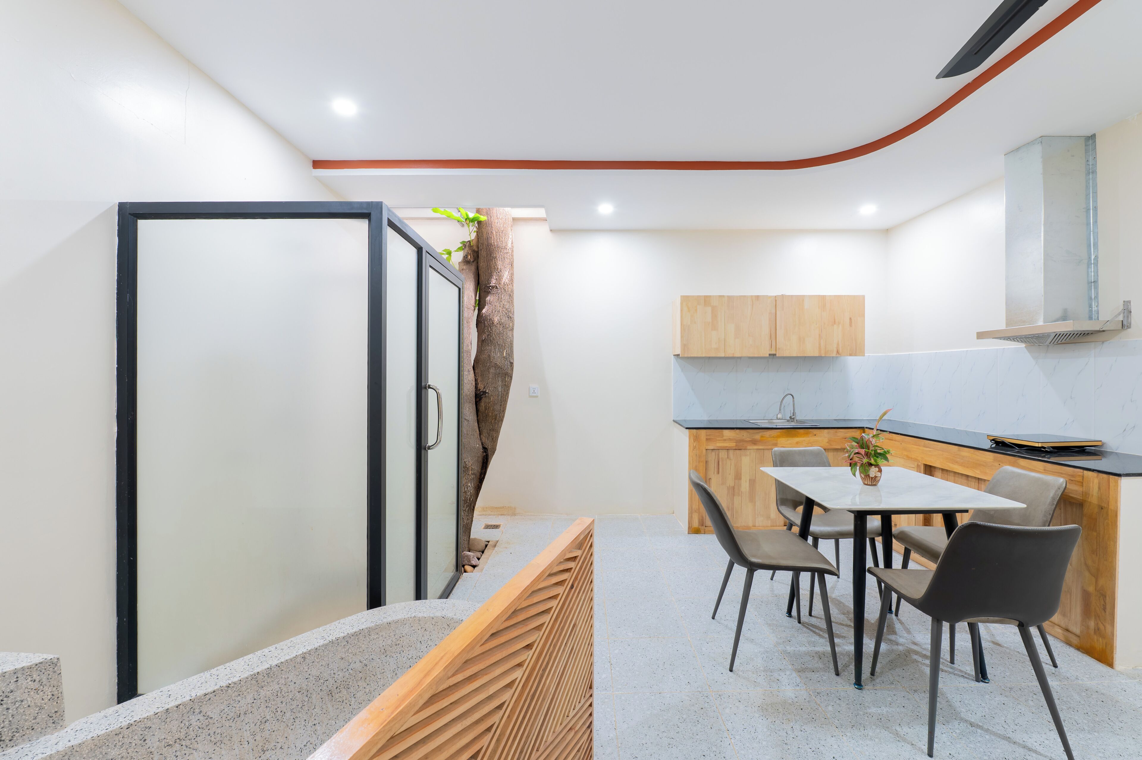 A modern kitchen with a wooden island, a dining area with chairs, and a built-in bench.