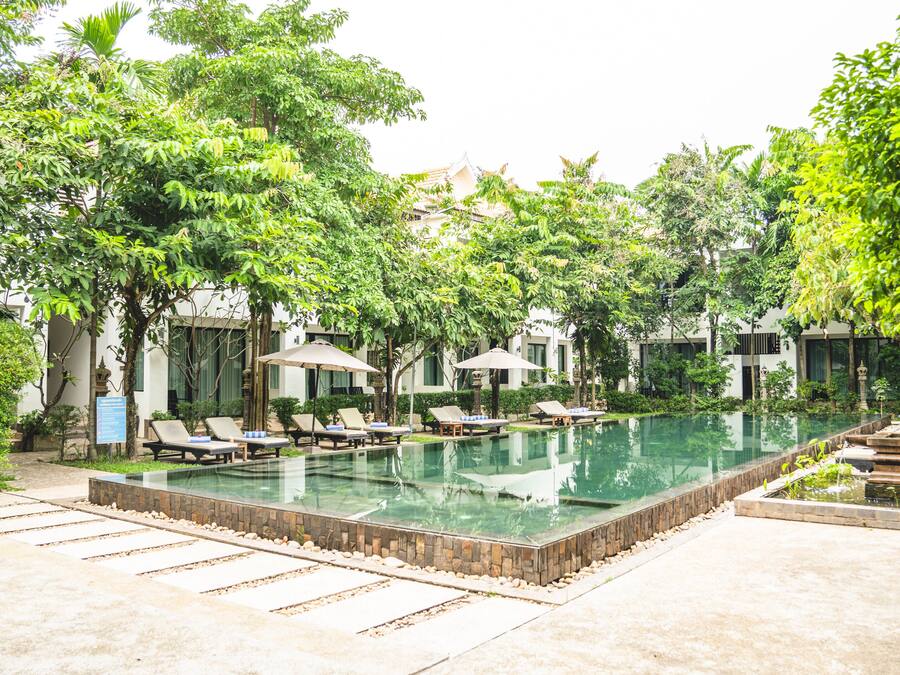 Una piscina al aire libre, camas de piscina gratis, sombrillas