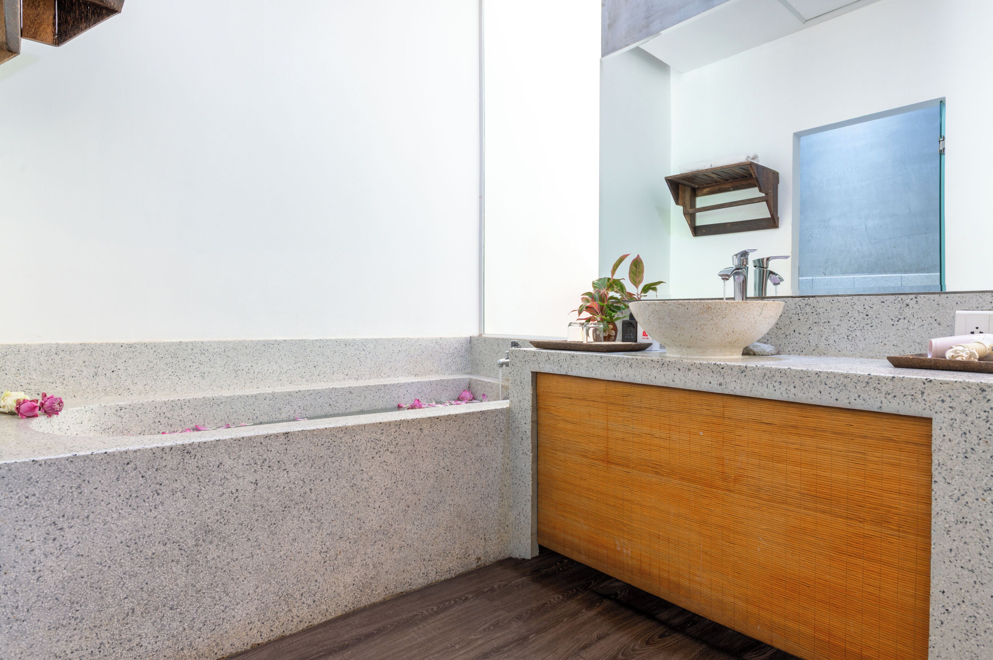 A bathroom with a freestanding bathtub, a sink with a vessel basin, and a mirror above the sink.