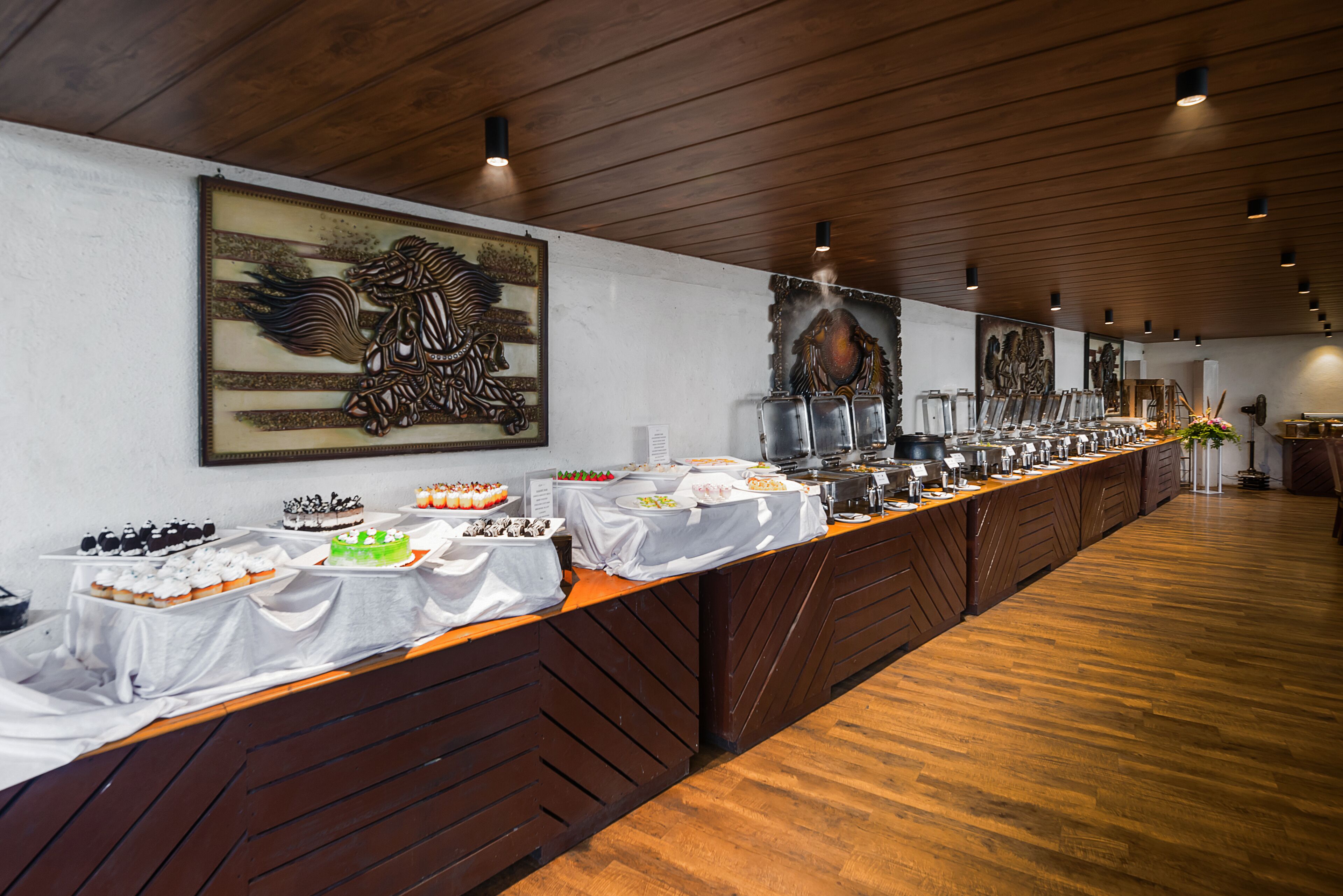 Montaje de bufé con diferentes opciones de comida y un cuadro decorativo grande en la pared.