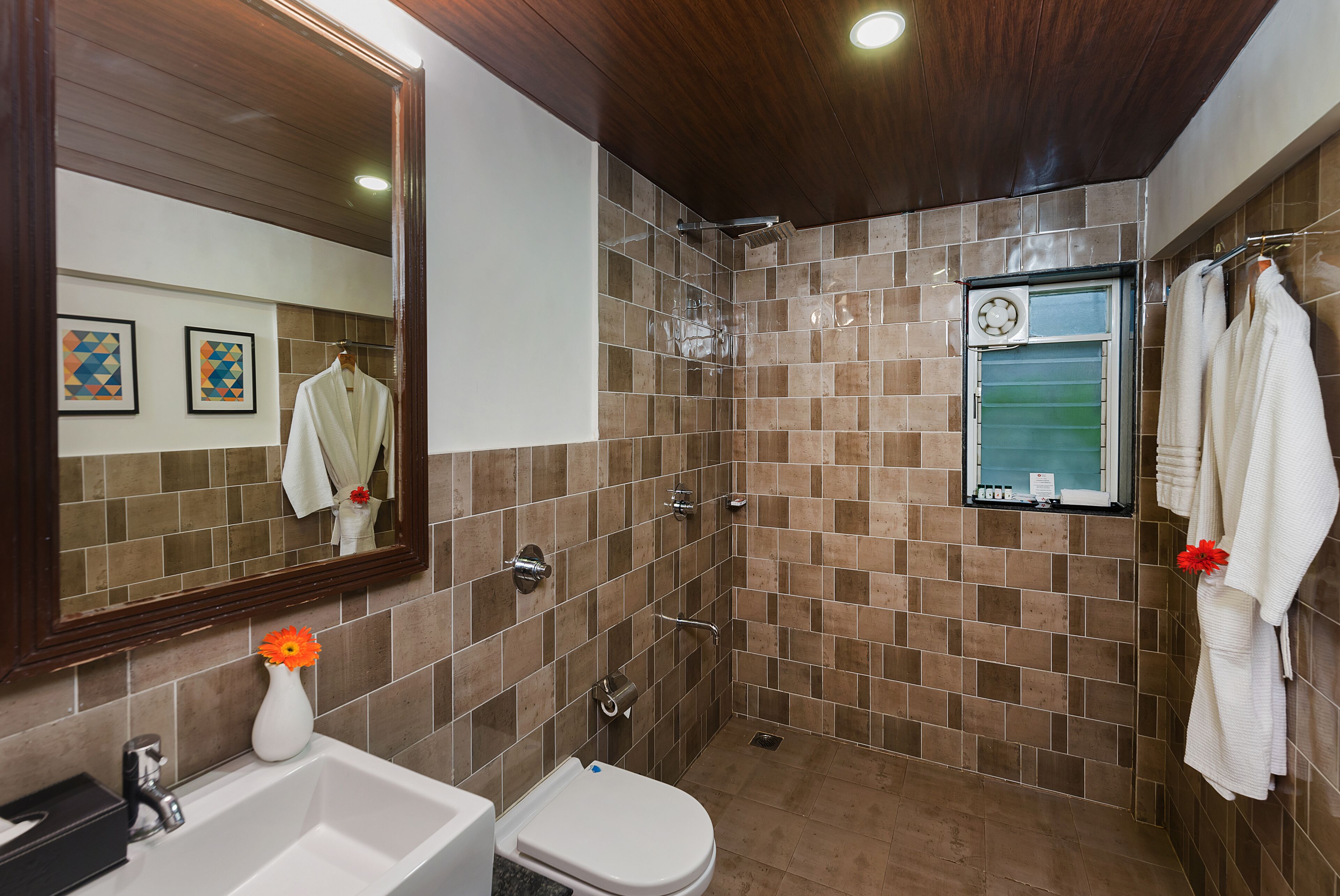 A bathroom with a shower, toilet, sink, and a mirror.