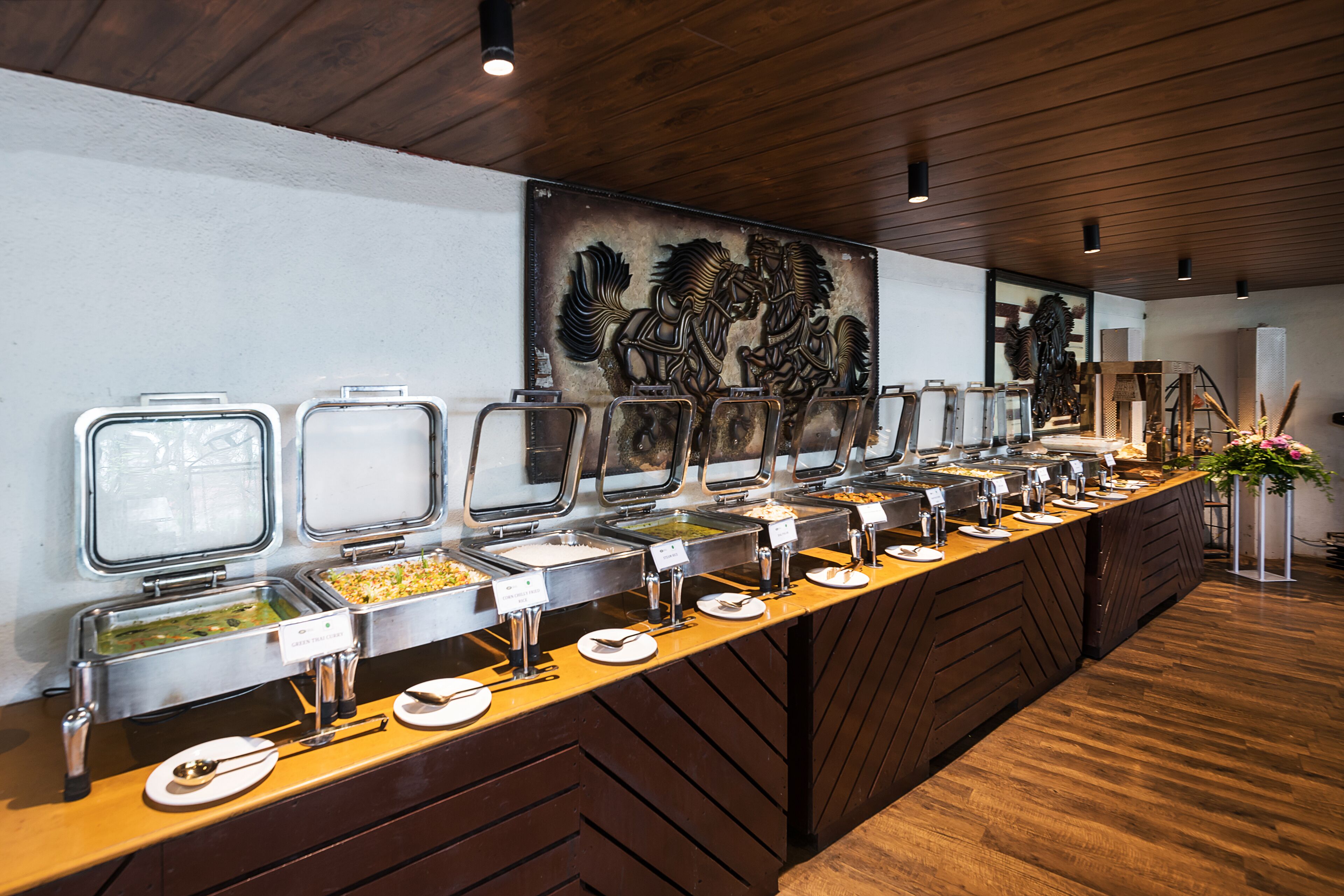 A buffet setup with multiple food containers and serving utensils.