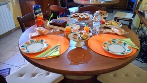 Une table à manger dressée avec des assiettes, des couverts et divers aliments.