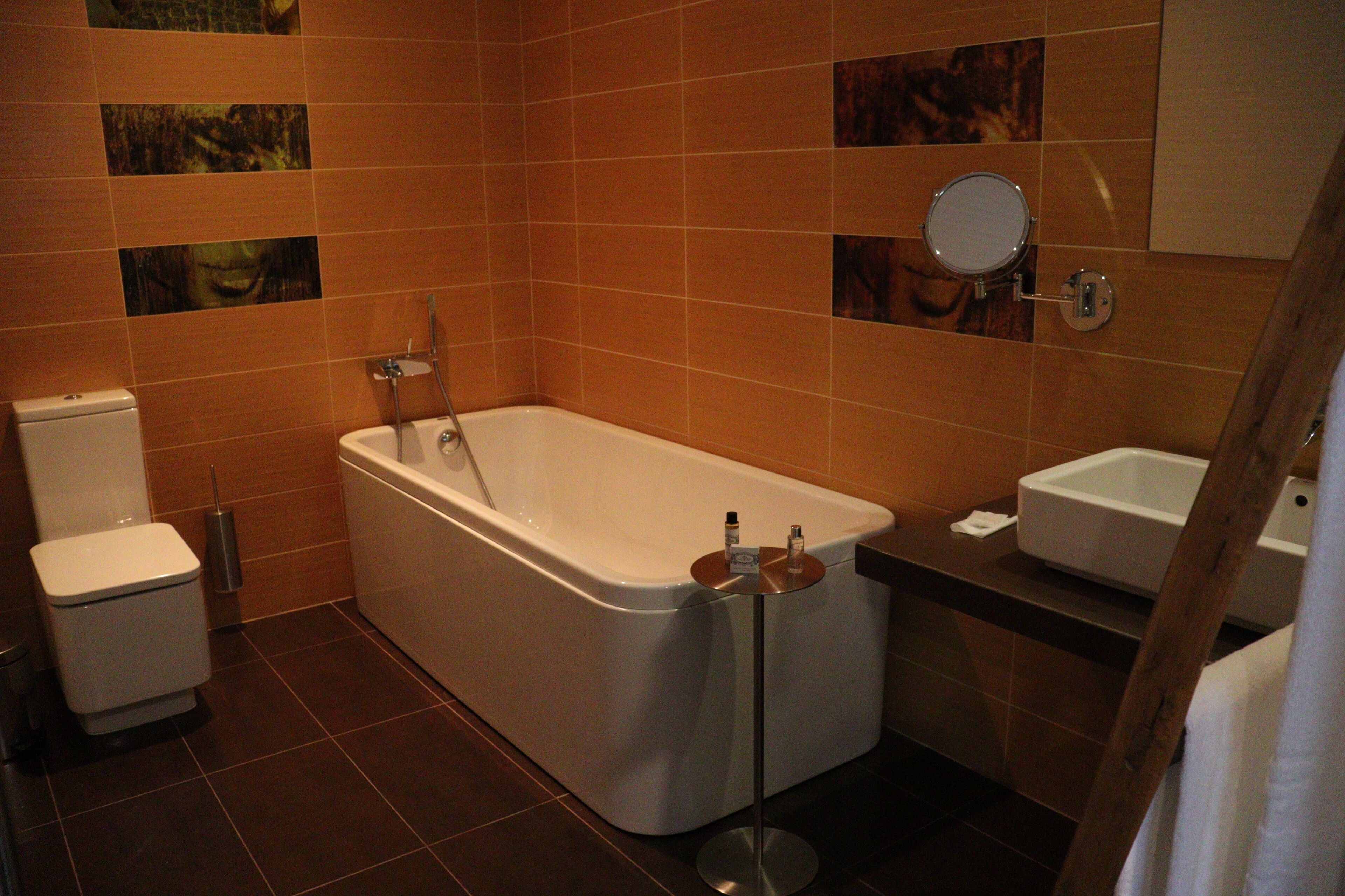 A bathroom with a bathtub, toilet, and sink.