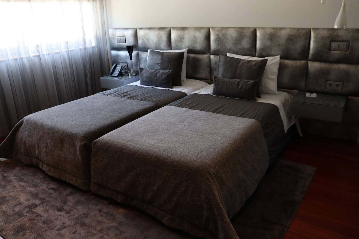 A double bed with a headboard, bedside tables, and a lamp.