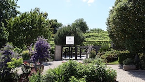 A landscaped garden with a sign for a restaurant and a gate. - FH Hotel (Felgueiras)