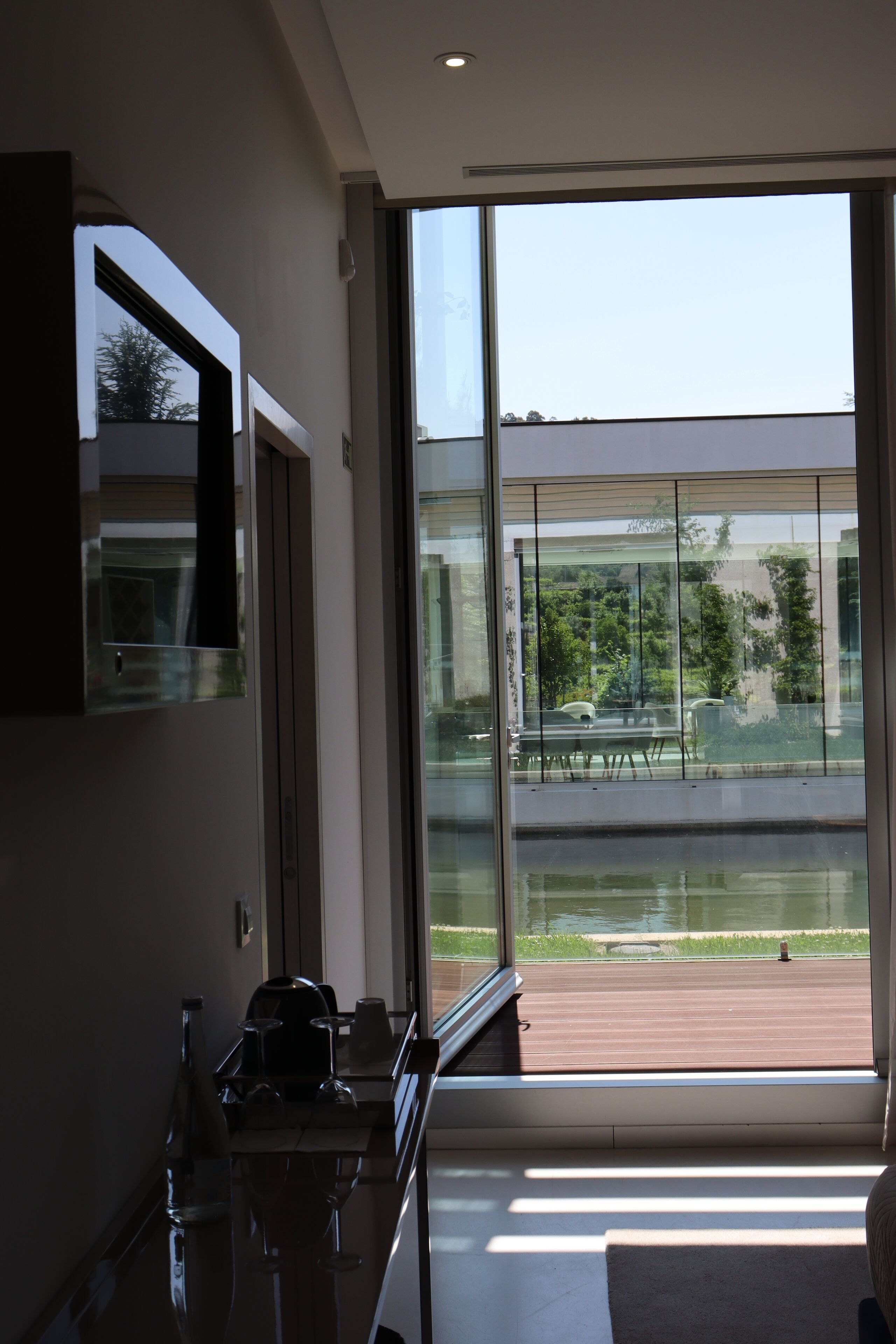 Una cocina moderna con un amplio ventanal que da a una terraza y una piscina.