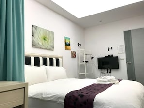 A hotel room with a bed, a TV, a painting, and a window. - Little Pianist Hostel (Hualien City)