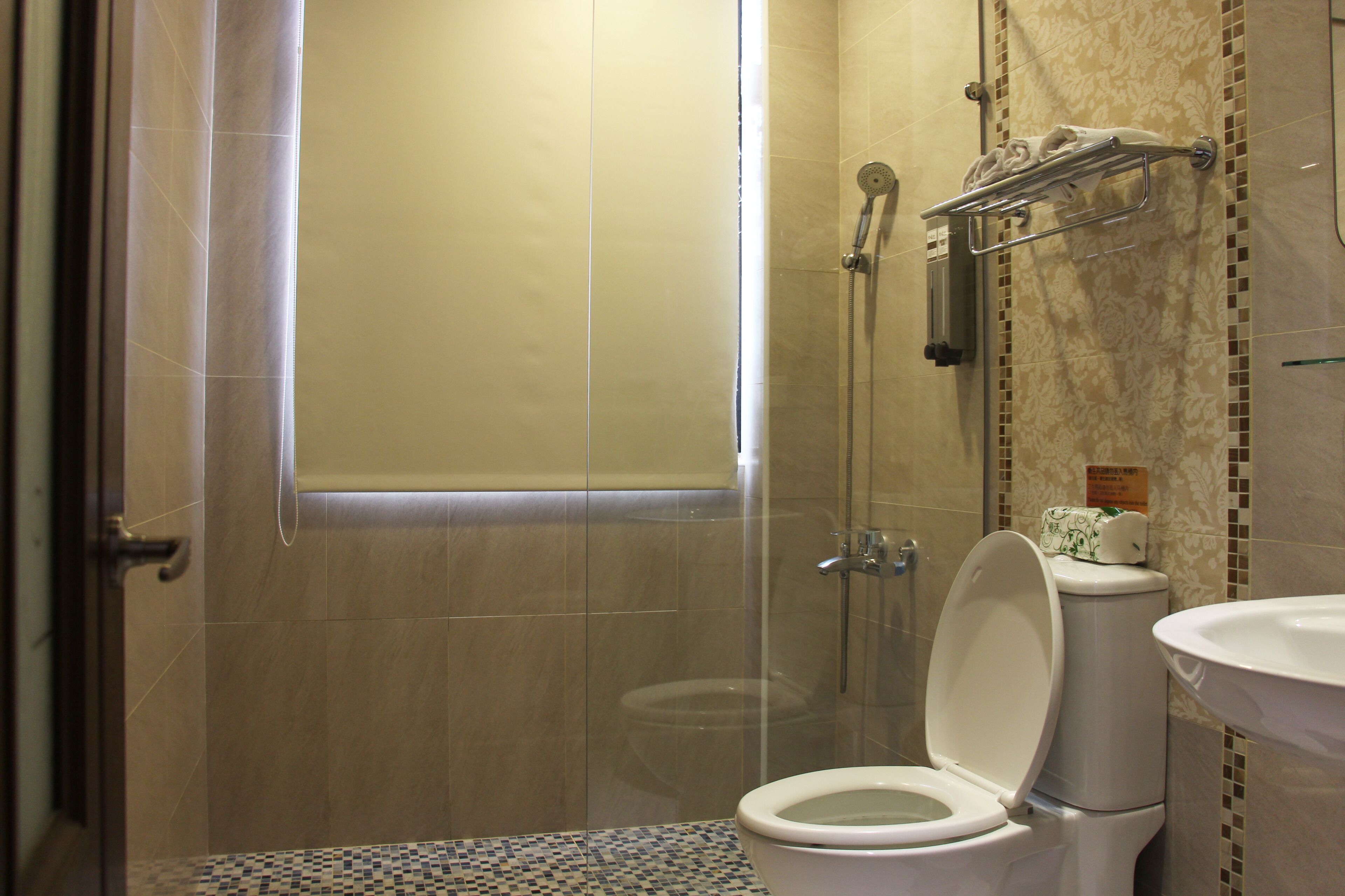 Une salle de bain avec des toilettes, une douche et un lavabo.