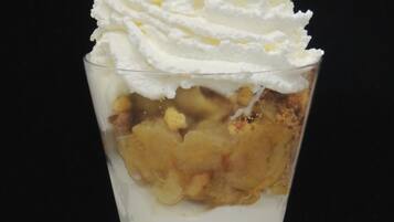 Un postre en un got amb capes de crema i fruita.