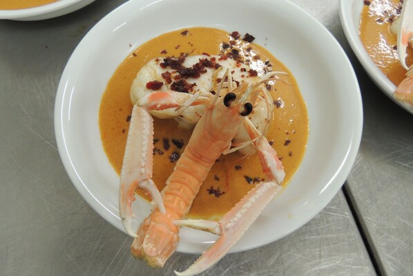 A plate with a seafood dish, including a lobster and a creamy sauce. - Auberge Denena Logis (Aicirits-Camou-Suhast)