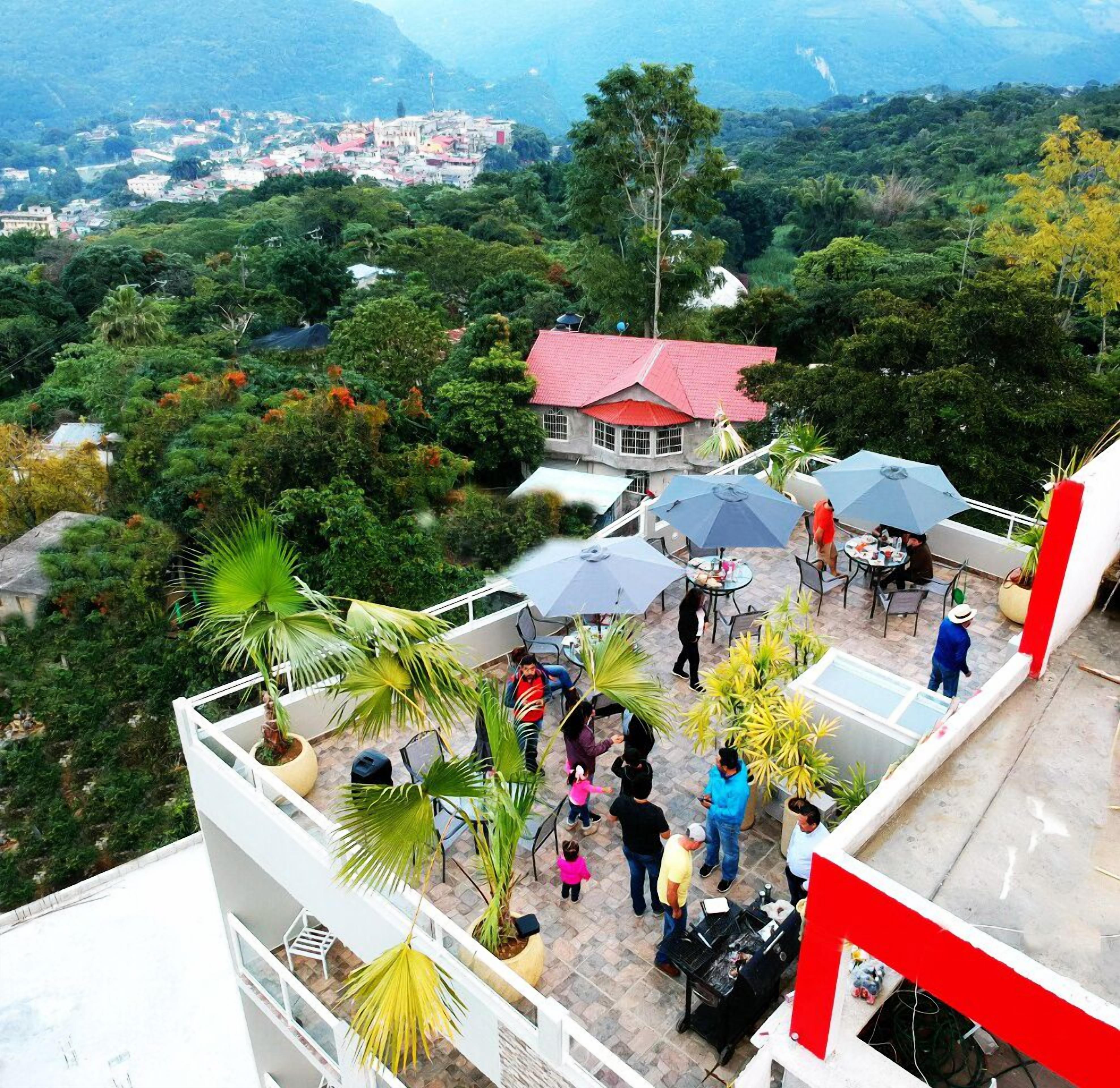 A rooftop terrace with outdoor seating and a view of a town in the background.