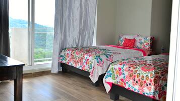 Un dormitorio con dos camas, un ventanal y vistas al exterior.
