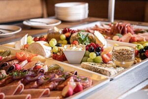Un tagliere con salumi, formaggi, frutta e noci.