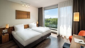 Une chambre d’hôtel avec un grand lit, un bureau et une vue sur le paysage urbain.