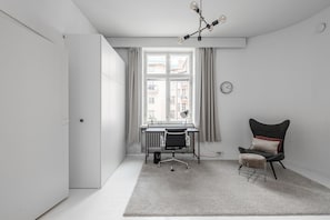 A modern room with a desk, chair, and a large window with curtains.