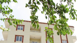 Un edificio de varios pisos con balcones, una escalera y una puerta con señalización.