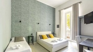 Una habitación de hotel con una cama, una cama individual, un escritorio y una silla.