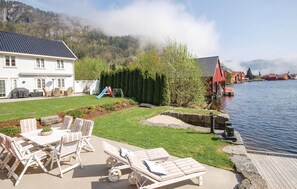 A lakeside property with a patio area, lounge chairs, a slide, and a view of the water and mountains. - Amazing home in Feda with WiFi (Feda)