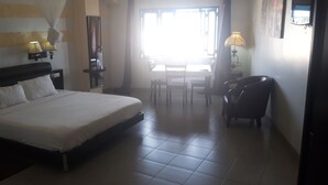 Une chambre d’hôtel avec un lit, des lampes de chevet, un bureau et une chaise.