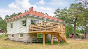 A two-story house with a red-tiled roof and a wooden deck. - Nice home in Vesterøy with WiFi (Vesterøy)