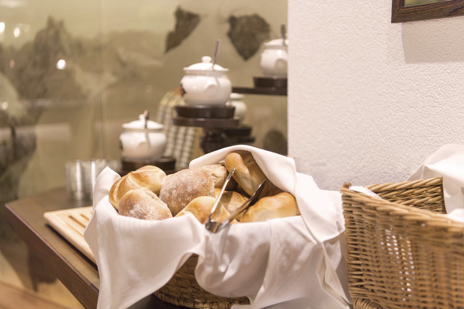 A basket of bread on a table with a white cloth.