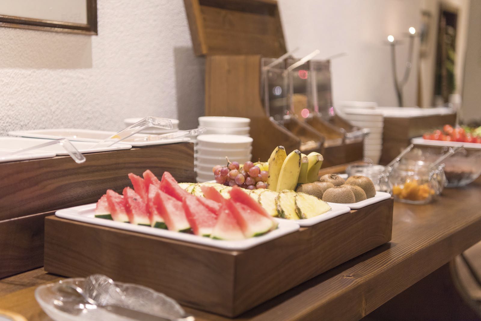Een buffet met verschillende soorten fruit en een houten toonbank.