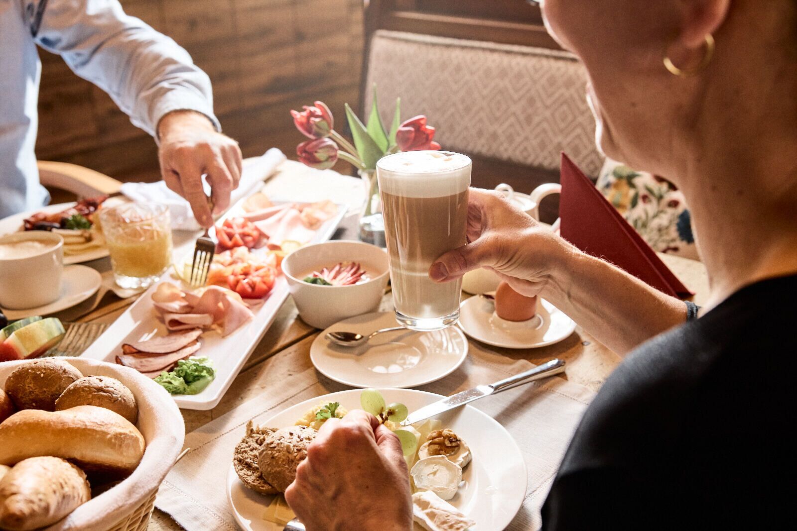 A breakfast buffet with various food items and a glass of milk.