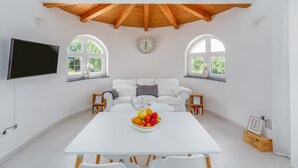 A spacious room with a white table, a sofa, and two windows. - Modern Villa Aria with beautiful garden and private Pool near Vrsar (Vrsar)