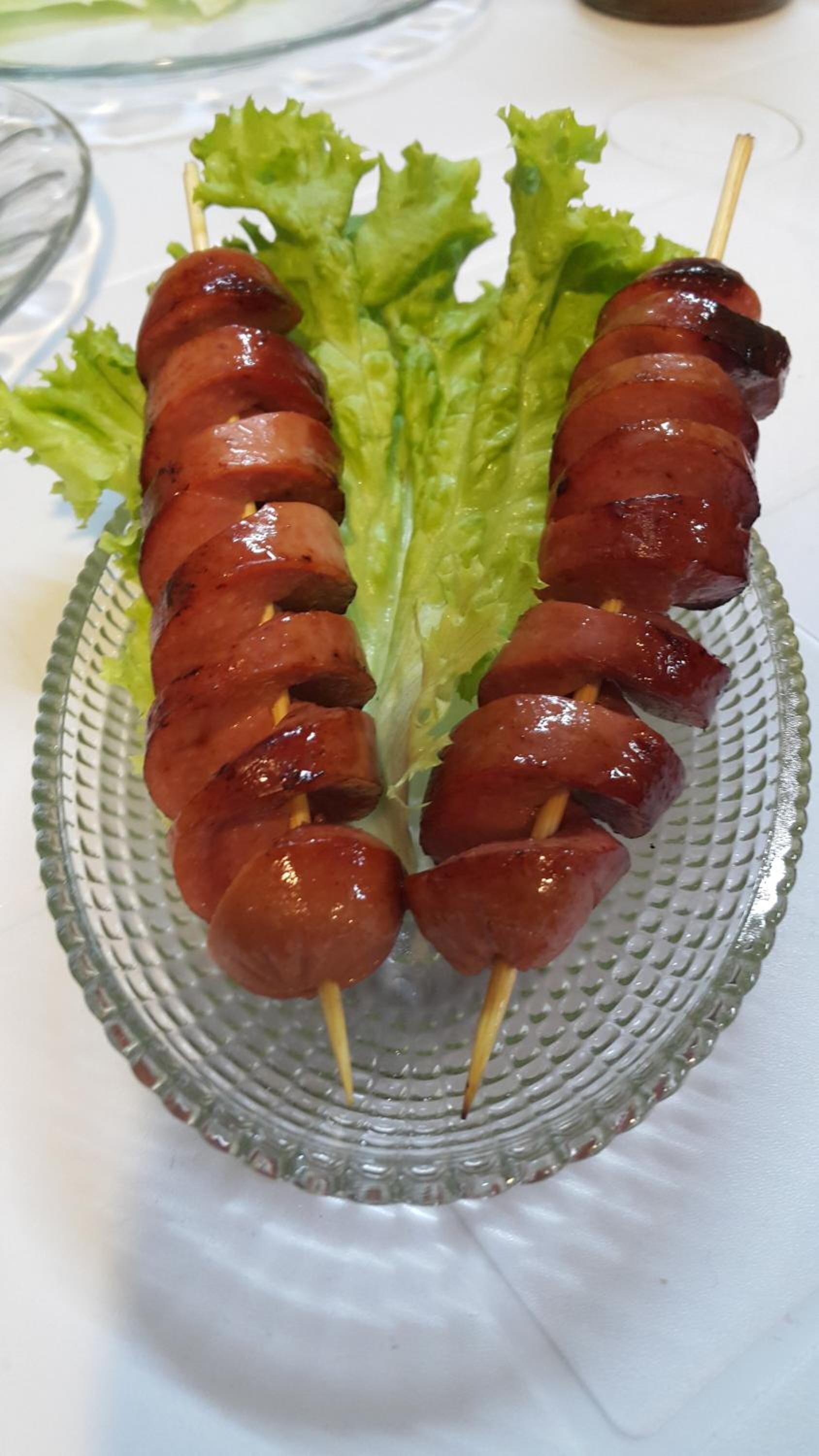 Un plato de brochetas de carne con lechuga.