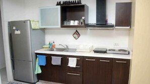 Uma cozinha compacta com geladeira, pia e armários.