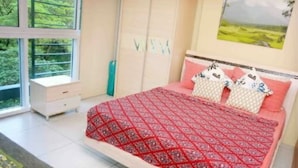 Quarto com uma cama, janela e guarda-roupa.