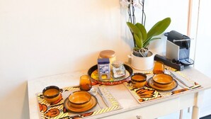 A kitchen area with a coffee machine, a plant, and various kitchen items on a tray.