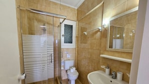 A bathroom with a glass-enclosed shower, a toilet, and a sink. - Corfu Island Apartment 148 (Corfu)