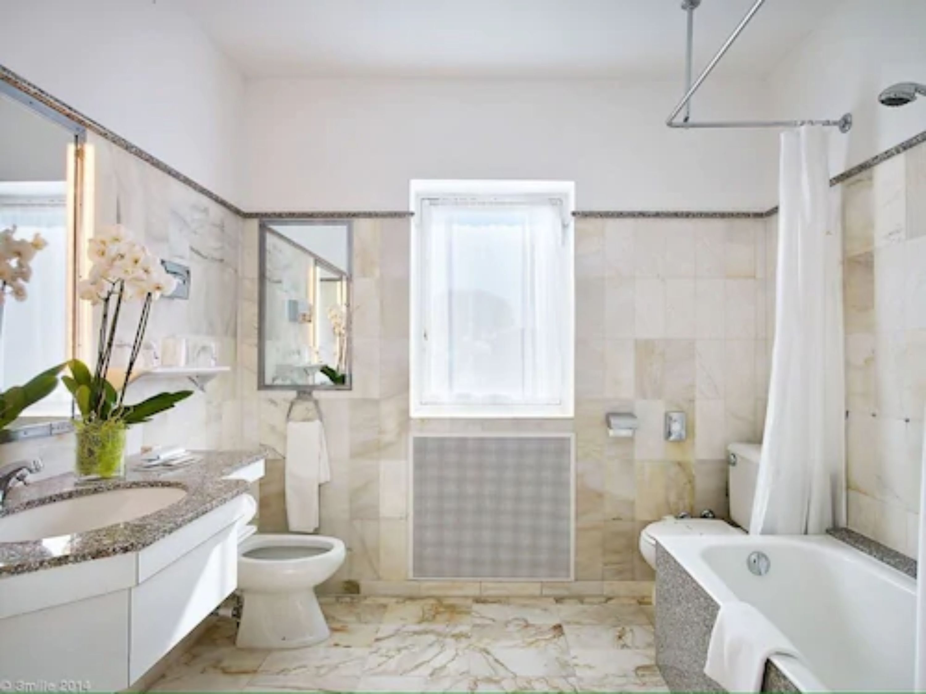 Ein Badezimmer mit Toilette, Waschbecken und Badewanne.
