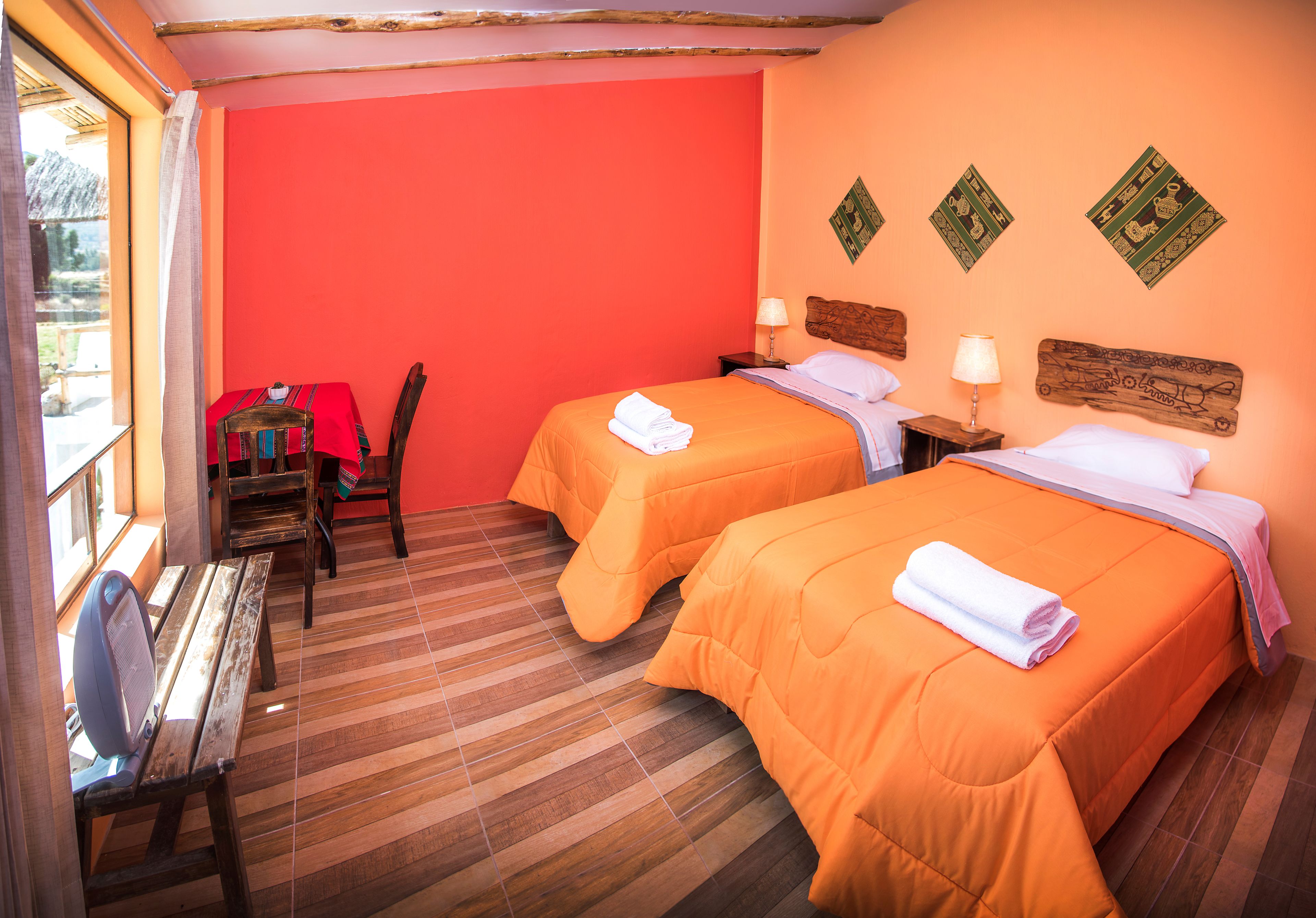 A room with two beds, wooden furniture, and a window.
