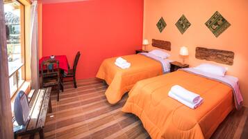 A room with two beds, wooden furniture, and a window.