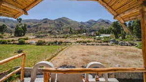 Une construction rustique en bois offrant une vue sur un paysage montagneux.