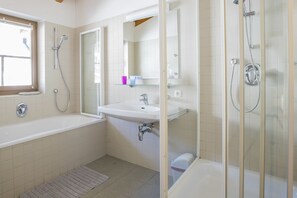A modern bathroom with a bathtub, a sink, and a shower enclosure. - Haus Wailand by Alpin Bookings (Dienten am Hochkoenig)