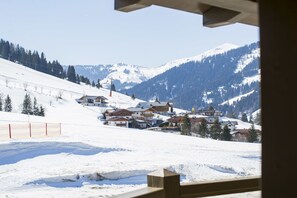 A snow-covered mountain village with houses and a ski lift. - Haus Wailand by Alpin Bookings (Dienten am Hochkoenig)