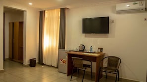 Habitación individual Deluxe | Zona de estar | Televisión de pantalla plana de 32 pulgadas con canales digitales
