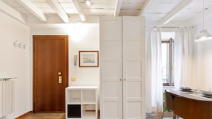 Ein modernes Interieur mit Holztür, weißer Regaleinheit und einem Essbereich mit Tisch und Stühlen.