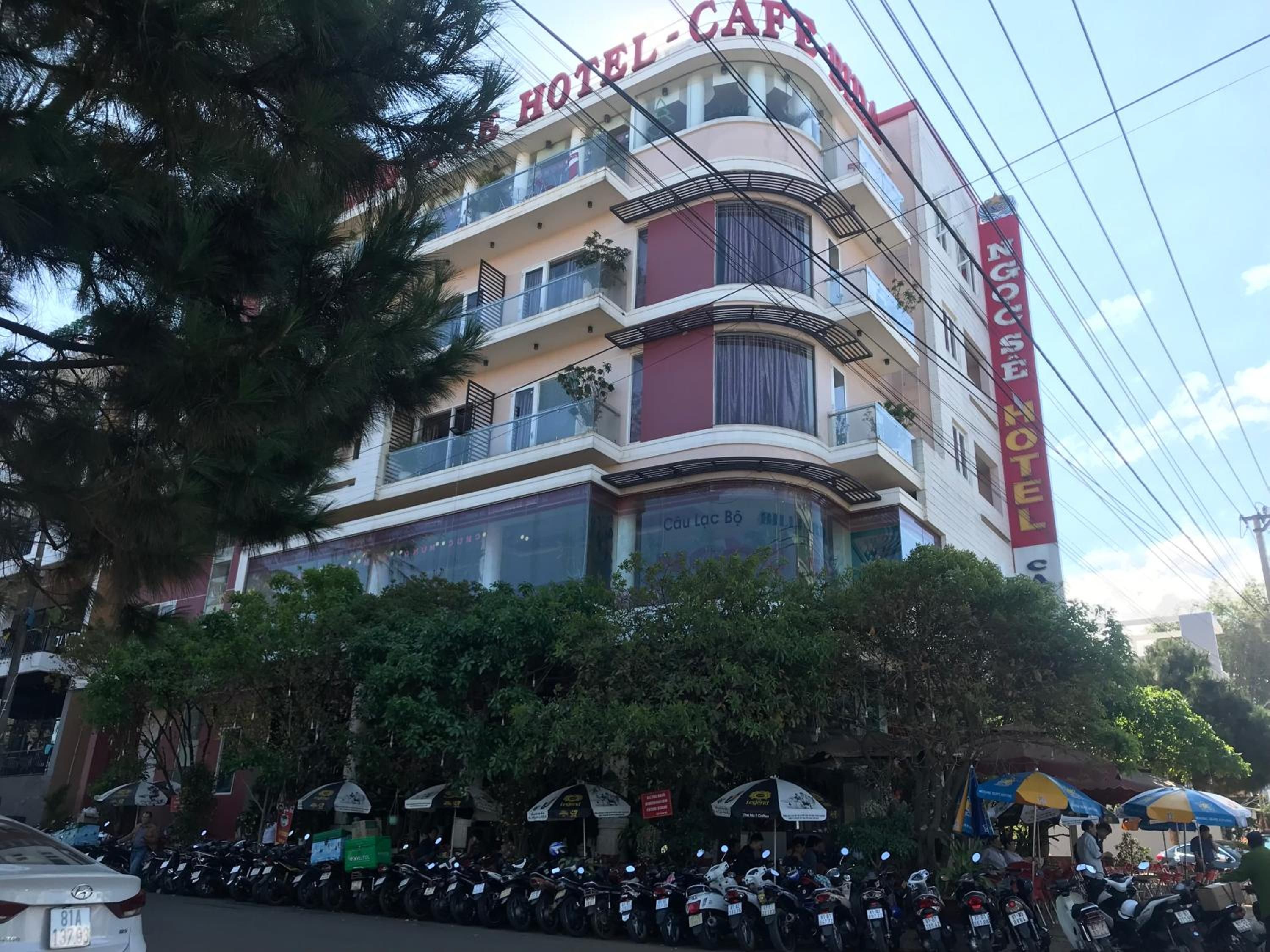 A multi-story hotel with balconies and a prominent red sign.