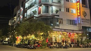 A multi-story hotel with a prominent coffee shop on the ground floor, featuring outdoor seating and a festive atmosphere. - Ngoc Se Hotel (Pleiku)