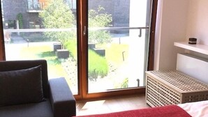 Makuuhuoneessa on sänky, sohva ja liukuoven kautta avautuva näkymä puutarhaan.